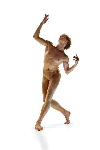 contemporary art ballet. young athletic man with naked torso in beige pants posing against white studio background. - motion art naked studio shot imagens e fotografias de stock