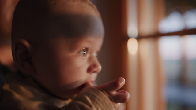 SLO MO Captivating Innocence: Baby Boy's Gaze at Camera while being Illuminated by Sunset Glow