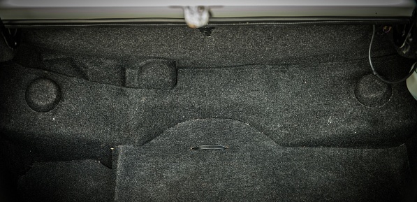 Trunk of a car open showing the carpet