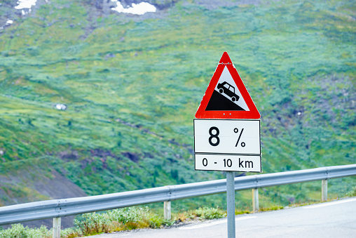 Road sign information about descending the road. Warning of steep descent on the road.