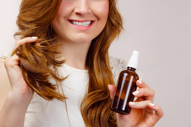 istock Woman applying hair cosmetic 1962771356