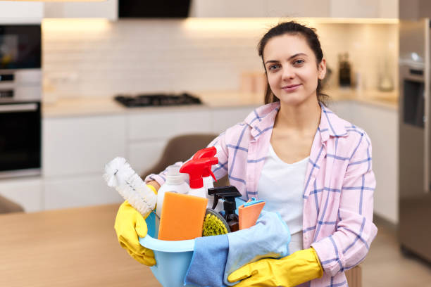 istock Woman in rubber gloves holding cleaning tools. 1962772440
