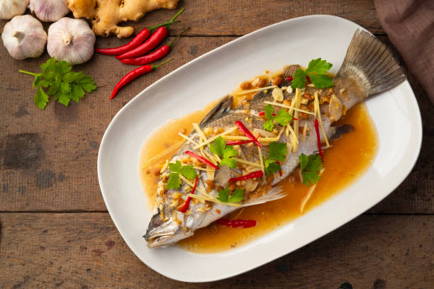 Steamed Seabass fish with Soybean Paste sauce in white plate.