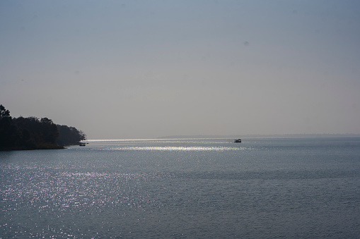 Water and beach on river with sky and trees