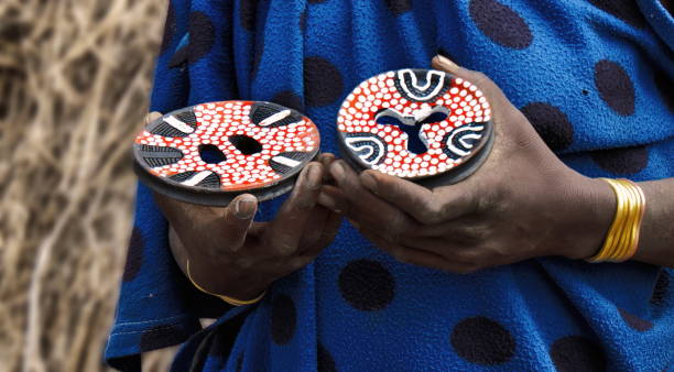 enfoque en la mano de una mujer africana sosteniendo placas labiales de cerámica a la venta en una aldea de la tribu mursi, valle del omo, etiopía - real people one person multi colored part of fotografías e imágenes de stock