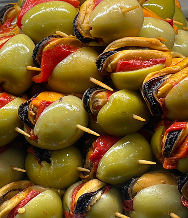 close up of a pile of stuffed olives, eaten as tapas, at a food market in the historic district of downtown Seville, Spain