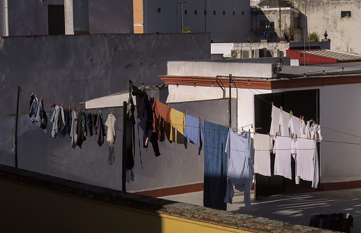 laundry drying outside on clotheslines set up on roofs in the historic district of Seville, Spain