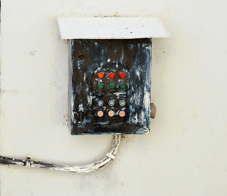 outdoor, wall mounted control box with buttons, used in the process of turning olives into olive oil, in the foothills of the Sierra del Pinar, in Andalusia, Spain