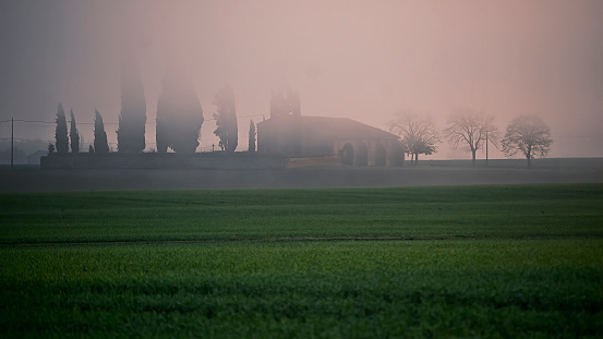Very old church looks like a mirage through the fog in Southern France