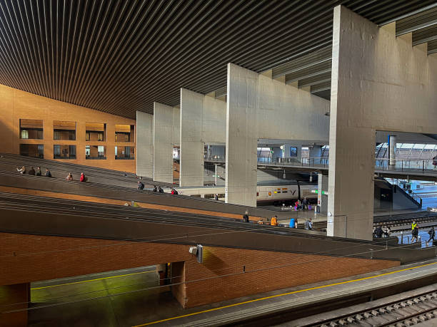 Casa de Campå metro station, Madrid, Spain, Europe, September 14, 2025:  Wide-angle view of Casa de Campo metro station in Madrid, showing multiple passengers waiting on both platforms as trains approach. The station features modern tiled flooring, overhead lighting, and digital display boards with real-time transit information.