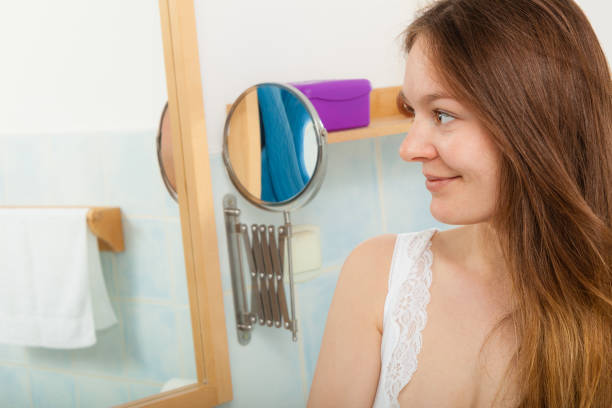Young girl woman without makeup in bathroom looking in mirror. Natural beauty. Purity.