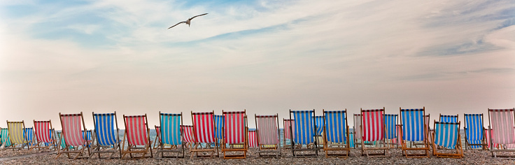 Line of deckchairs on pebble beach, United Kingdom