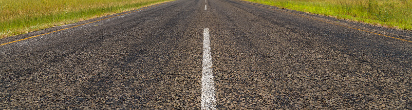 Empty intercity road with asphalt surface and white markings in evening.