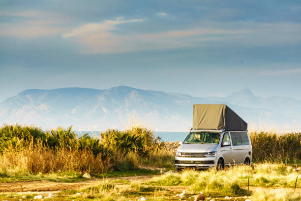 istock Van with roof top tent camping on nature 1962905103