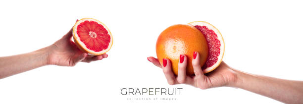 istock Juicy fresh grapefruit in a beautiful woman's hand isolated on white 1962917277