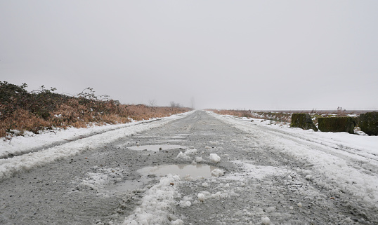 Slushy byroad at Rannie Road near the Grant Narrows Regional Park and Pitt River Dike during a snowy winter season in Pitt Meadows, British Columbia, Canada.