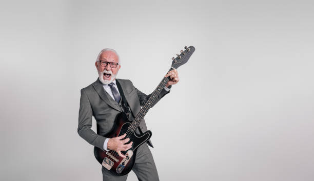 istock Old male entrepreneur screaming and playing electric guitar while performing on white background 1962965291
