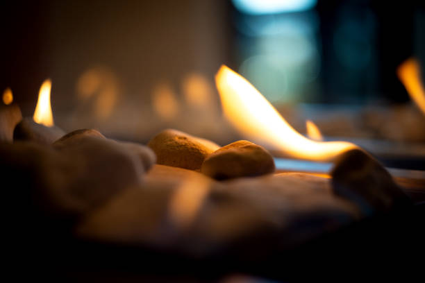 A fire burns in a glass fireplace, radiates heat