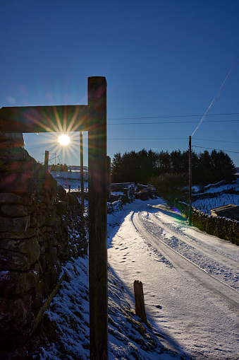 January and the afternoon after a sudden fall of snow the winter sun begins to settle above the horizon. Nidderdale. North Yorkshire.