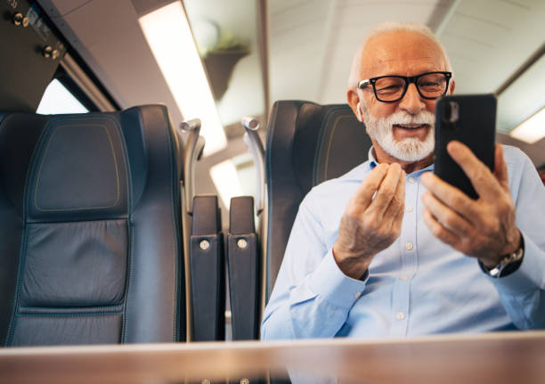 istock Senior businessman using his mobile phone while traveling with train 1962986797