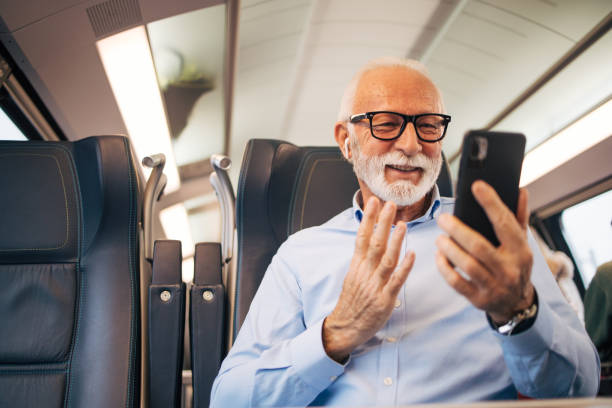 istock Senior businessman using his mobile phone while traveling with train 1962987309