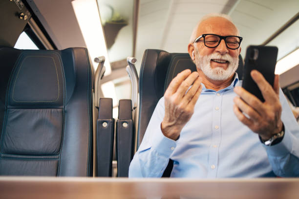 istock Senior businessman using his mobile phone while traveling with train 1962987313
