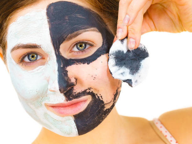 istock Girl remove black white mud mask from face 1962988883