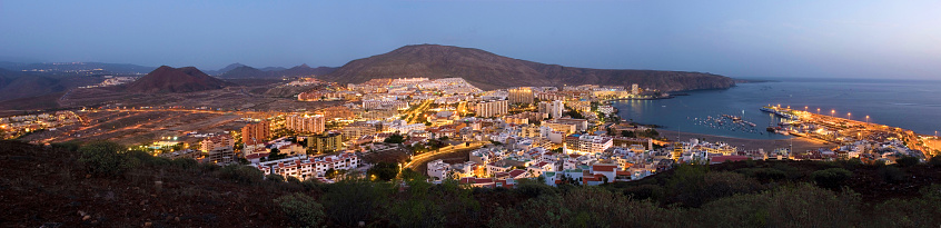 Los Cristianos in the evening at sunset, blue hour, panoramic shot with harbor, volcanoes and sea, Tenerife, Canary Islands, Spain