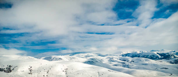 Snowy mountains with white clouds stock photo