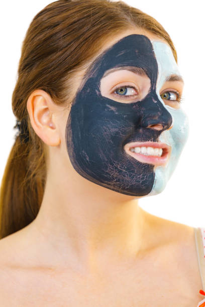 istock Girl with black white mud mask on face 1962998943