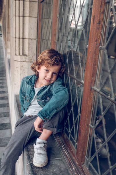 istock Charming boy sitting near window outside 1963009073