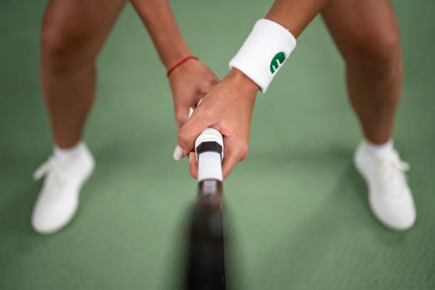 Male tennis player holding racket close up selective focus