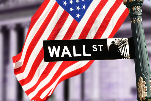 wall street sign with US flag in Manhattan, New York, USA