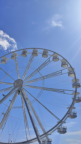 Ferris wheel seen from below against clear blue sky