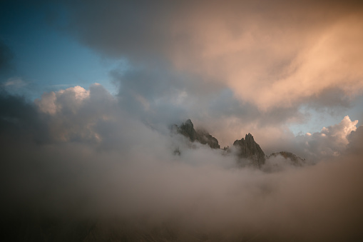 Scenic view of tall mountain range in Trentino valley, Italy. Beautiful sky above. Green valley stretching between the mountains. Parco Naturale Tre Cime