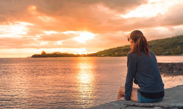istock Woman enjoying beautiful sunset by the ocean. 1963076842