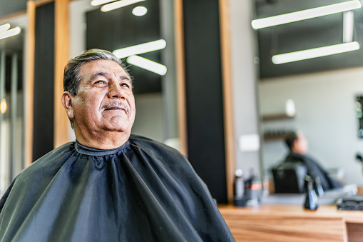 Senior man looking away contemplating at barber shop