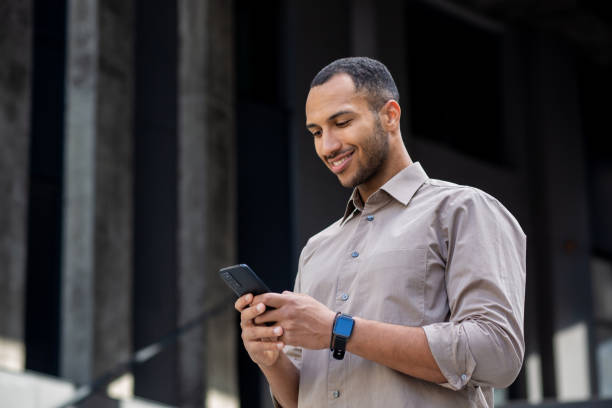 istock Confident young professional african american man using smartphone outside office 1963091444