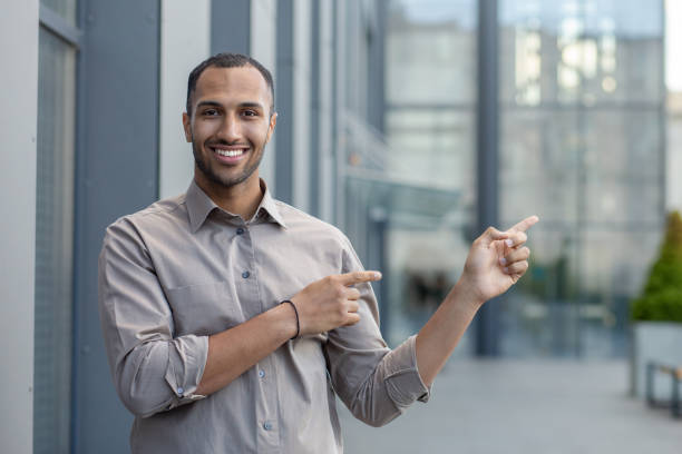 istock Confident young businessman pointing while walking in urban setting outdoors 1963092010