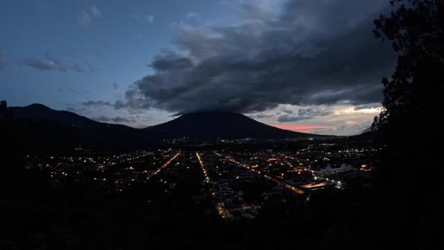 Night falls on the Agua volcano and the city of Antigua in Guatemala.