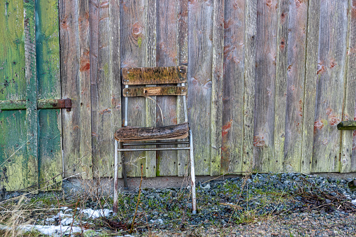 A wooden chair stands in the middle of a field.A chair in the middle of the field. The concept of loneliness and emptiness. Depression