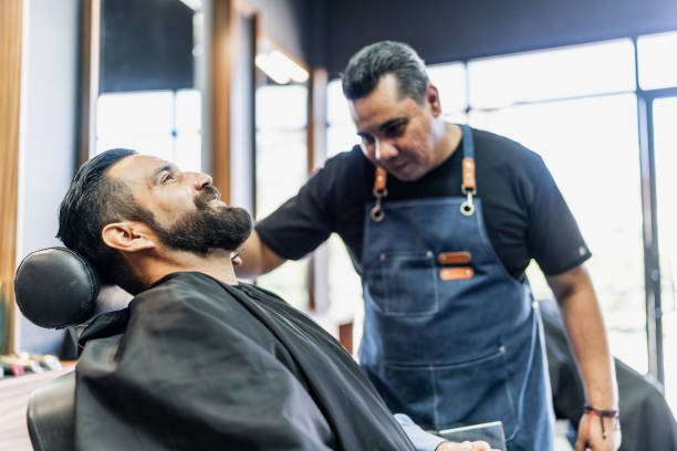 istock Barber getting his beard cut from customer at barber shop 1963120453