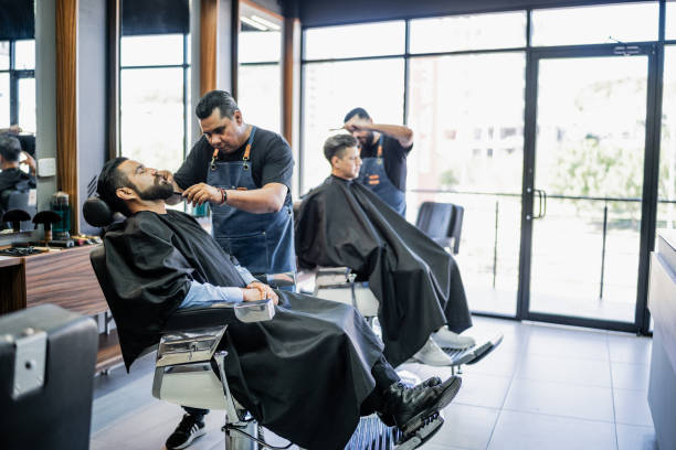 istock Barber getting his beard cut from customer at barber shop 1963120653