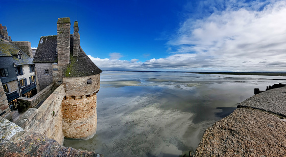 A pictoresque angle of the Mont Saint Michel, in north of France, with the view from the ramparts of a tower and the low tide in the bay