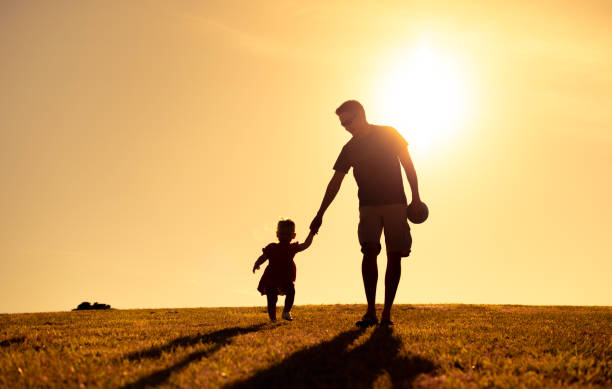 istock Father and daughter walking at sunset. 1963170292