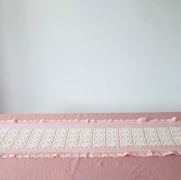 background with pink tablecloth with lace and white wall