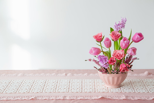 pink flowers in vase on background white wall