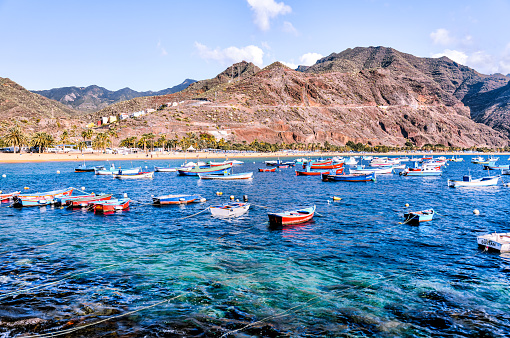 Tenerife, Spain - December 25, 2023: Fishing boats anchored along the shores of Playa de las Teresitas on the island of Tenerife in Spain's Canary Islands