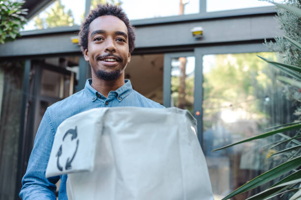 istock Young man holding a recycling bag and a plastic bottle 1963210941