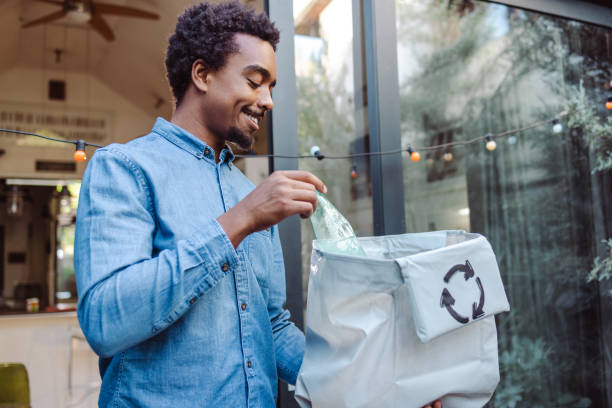 istock Young man holding a recycling bag and a plastic bottle 1963210944